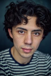 close up headshot featuring actor Benjamin Radstone highlighting feckless skin taken by photographer Kim Hardy in his London studio in front of a dark blue background