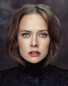 Headshot of actress Amelia Eve taken by photographer Kim Hardy in his London studio featuring blue eyes in front of a dark background