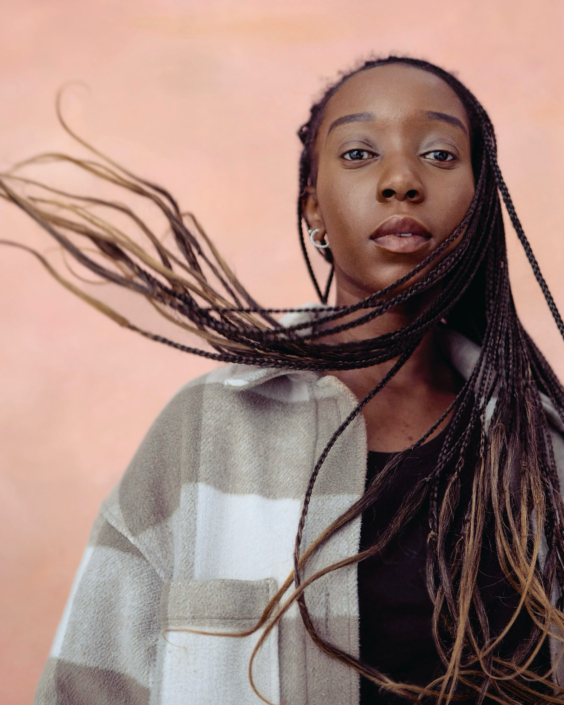 acting headshot of young black woman with flying hair taken by photographer Kim Hardy in his London studio using a peach coloured background