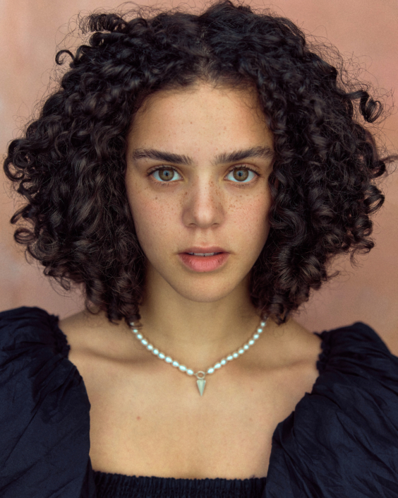 professional acting headshot of Safia Oakley Green wearing a pear necklace by Kim Hardy taken in a London studio in front of a peach background