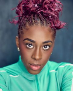 Headshots of Cherece Richards black actress with pink hair in a bright green top taken by Kim Hardy photographer in his London studio in front of a blue background