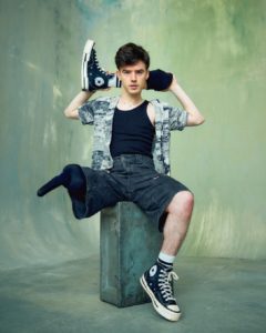 creative headshot of a young actor called Matthew Nolan who has a prosthetic leg that he is holding behind his head taken by photographer Kim Hardy in his London studio in front of a green background