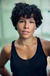 headshot of Rhiannon Skerritt wearing a black tank top in front of a green background photographed by Kim Hardy in his London studio