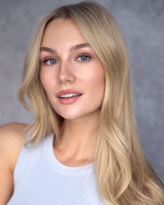 headshot of young blond actor with blue eyes wearing a white top taken by Kim Hardy in his London photography studio in front of a grey background