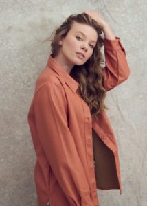 creative headshot of a young actor Jessie Armer wearing a salmon coloured top taken by Kim Hardy in his London studio in front of a textured backdrop