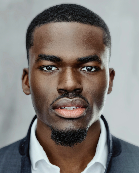 headshot of young black actor in front of a light grey background taken by photographer Kim Hardy in his London studio